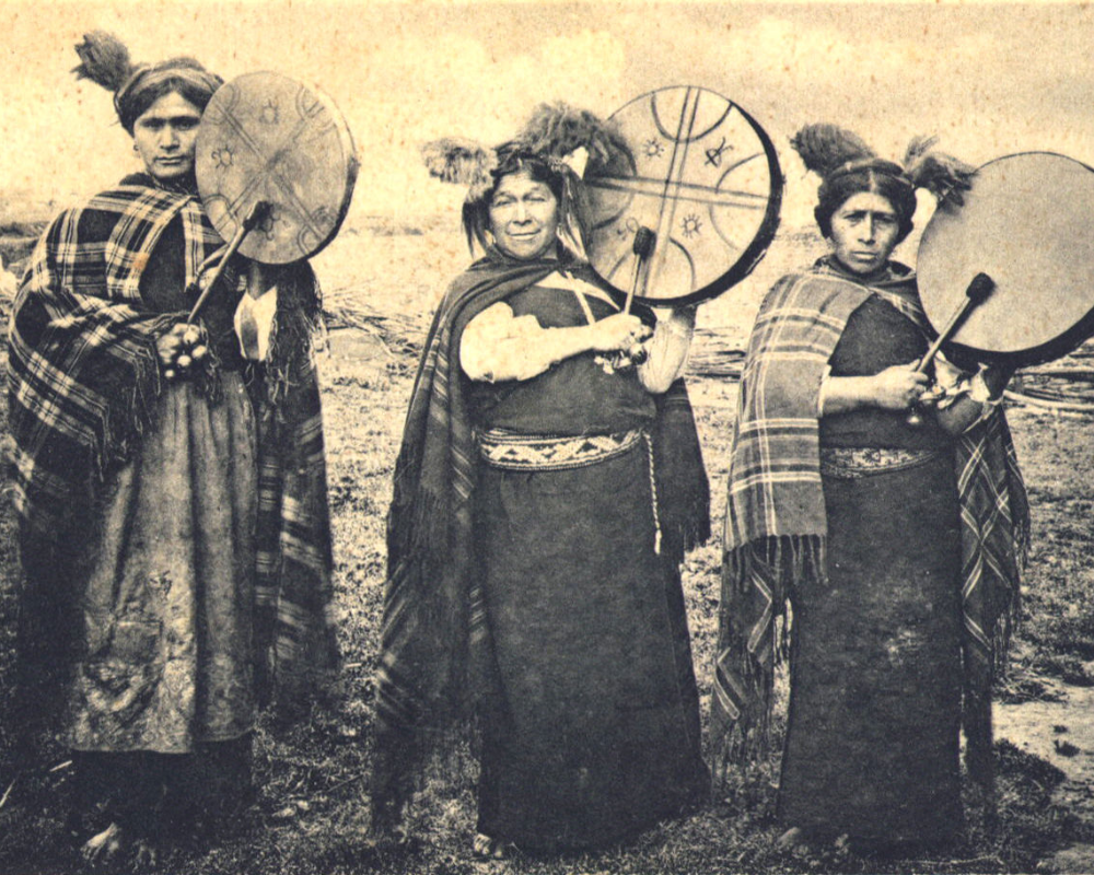 Fotografía histórica de mujeres mapuches, pueblos originarios de América, tocando el Kultrún